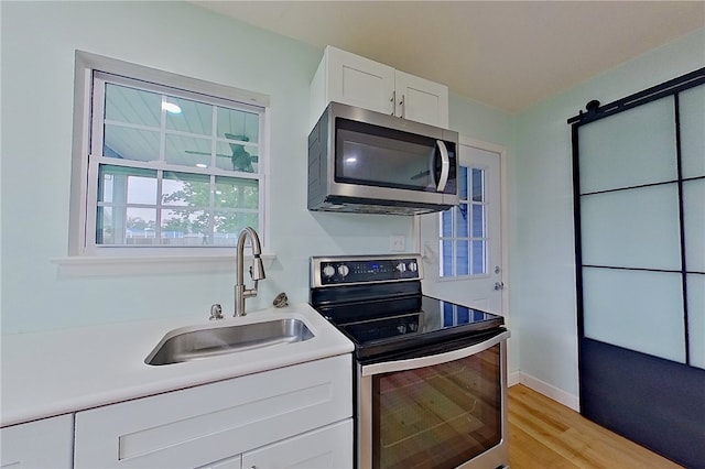 20 Marla St, Hoboken, GA 31542 - kitchen featuring stainless steel appliances, a sink, white cabinetry, light countertops, and light wood-type flooring