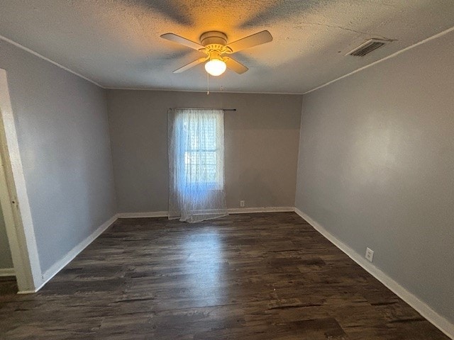 empty room featuring ceiling fan, dark wood-type flooring, and a textured ceiling