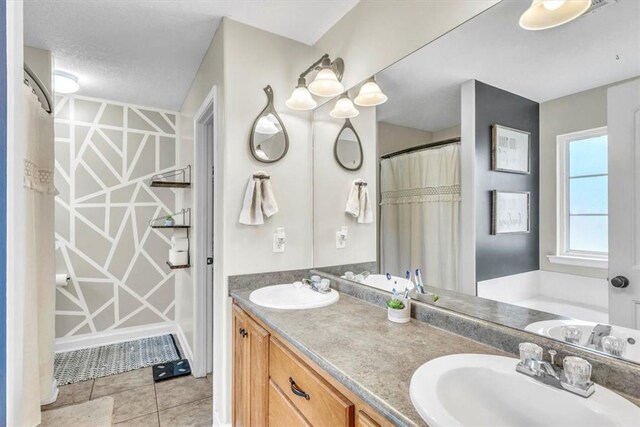 bathroom with tile patterned floors, vanity, and a textured ceiling