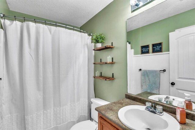 bathroom with vanity, a textured ceiling, and toilet