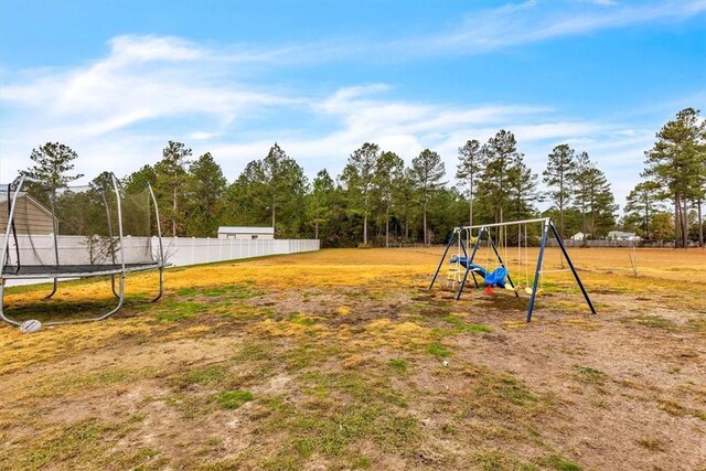 view of yard featuring a playground and a trampoline