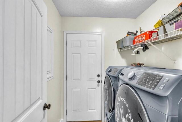 washroom featuring washer and clothes dryer and a textured ceiling