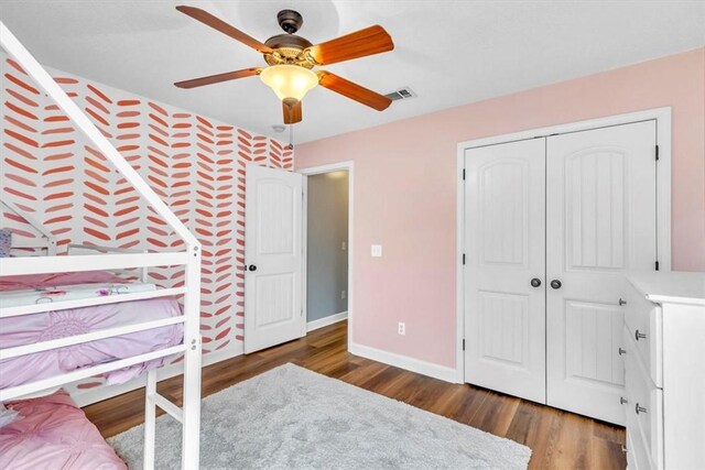 bedroom with ceiling fan, a closet, and dark wood-type flooring