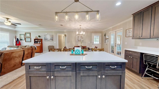 kitchen with dark brown cabinetry, french doors, a kitchen island, and light hardwood / wood-style floors