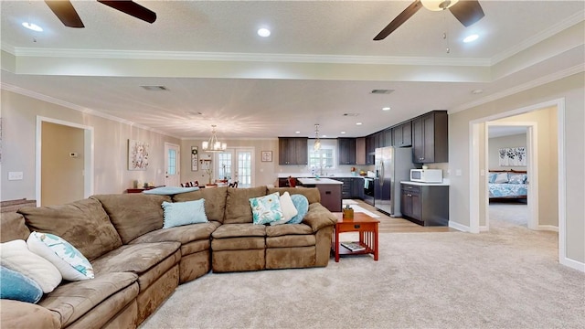 living room with light carpet, ceiling fan with notable chandelier, and crown molding
