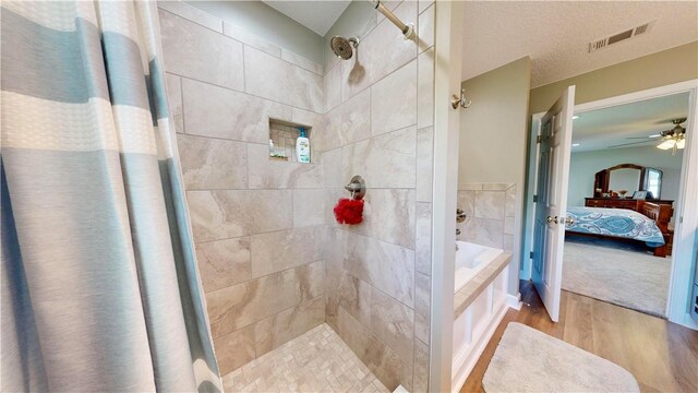 bathroom with wood-type flooring, a textured ceiling, and independent shower and bath