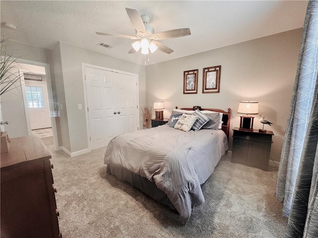 carpeted bedroom featuring ceiling fan, a textured ceiling, and a closet