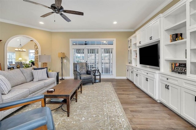 living room featuring ceiling fan with notable chandelier, light hardwood / wood-style flooring, and ornamental molding