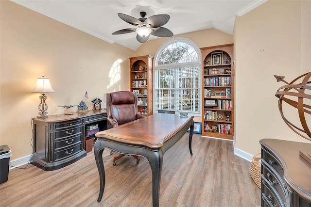 office space featuring crown molding, light hardwood / wood-style flooring, vaulted ceiling, and ceiling fan