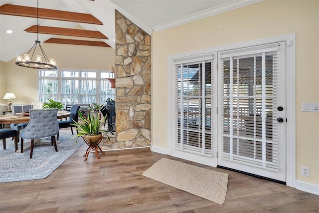 entryway with hardwood / wood-style floors, crown molding, an inviting chandelier, and lofted ceiling with beams