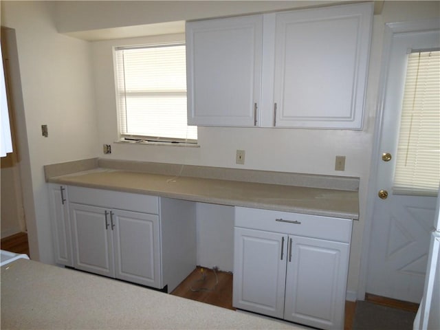 kitchen featuring white cabinetry, dark hardwood / wood-style flooring, and built in desk