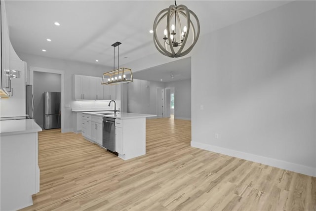 231 Salt Creek Way E, Brunswick, GA 31523 - kitchen with dishwashing machine, freestanding refrigerator, a chandelier, open floor plan, and light countertops