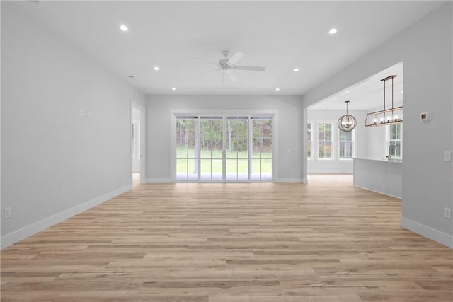 231 Salt Creek Way E, Brunswick, GA 31523 - unfurnished living room featuring recessed lighting, a ceiling fan, a chandelier, light wood finished floors, and baseboards