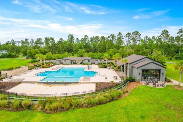231 Salt Creek Way E, Brunswick, GA 31523 - community pool featuring a patio area and view of wooded area
