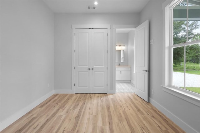 231 Salt Creek Way E, Brunswick, GA 31523 - unfurnished bedroom featuring light wood-style floors, baseboards, a closet, and ensuite bathroom