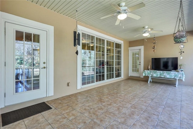 unfurnished sunroom with wooden ceiling and ceiling fan