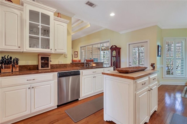 kitchen with ornamental molding, visible vents, light wood-style floors, and stainless steel dishwasher