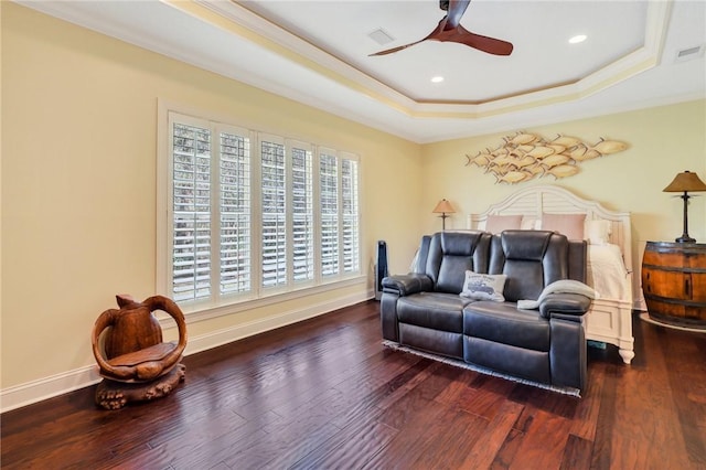 bedroom featuring baseboards, crown molding, a tray ceiling, and wood finished floors