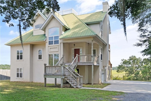 view of front of home featuring a front lawn, covered porch, and a garage