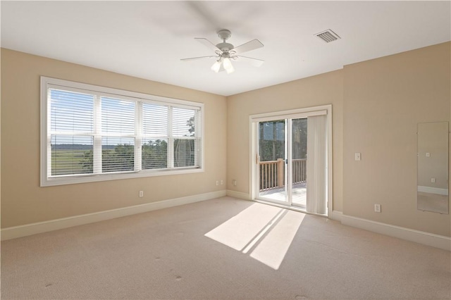 carpeted spare room featuring ceiling fan