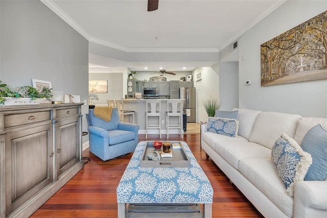 living room featuring dark wood-style floors, crown molding, and a ceiling fan