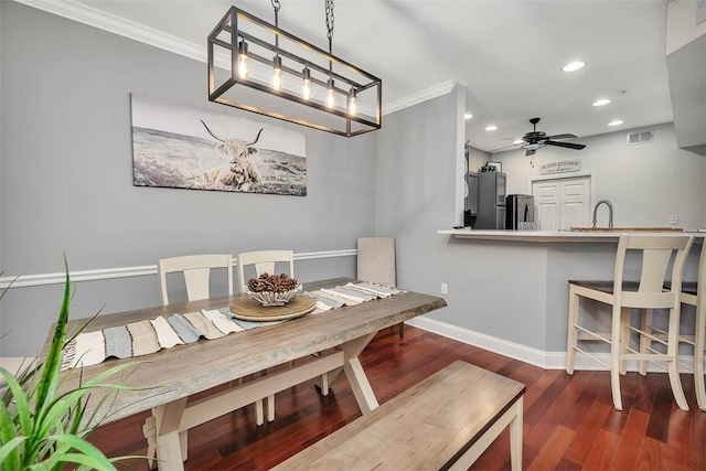 dining space with crown molding, dark wood finished floors, recessed lighting, a ceiling fan, and baseboards