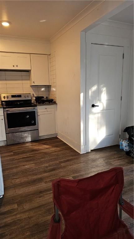 kitchen with dark wood-type flooring, white cabinetry, tasteful backsplash, stainless steel electric range oven, and ornamental molding