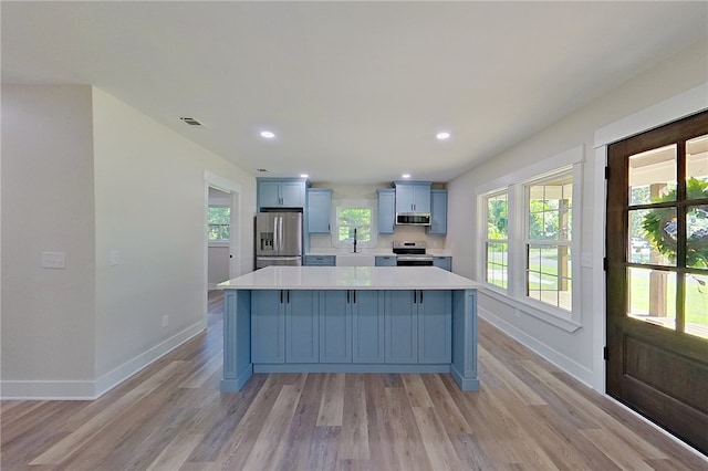 880 Miles Still Rd, Waycross, GA 31503 - kitchen featuring stainless steel appliances, baseboards, light countertops, blue cabinetry, and recessed lighting