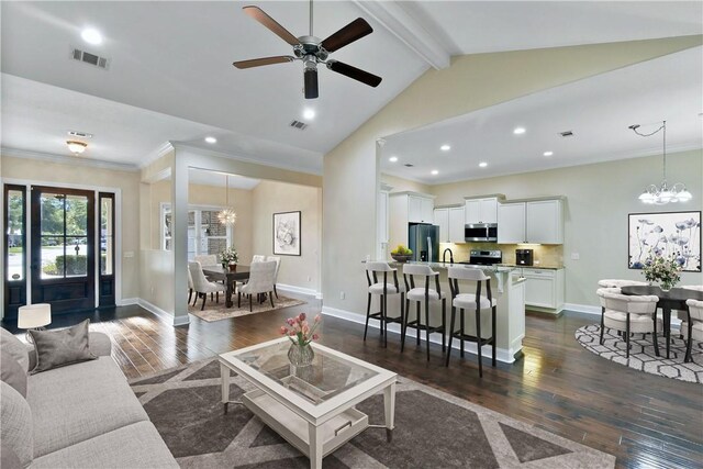 kitchen featuring vaulted ceiling with beams, dark wood-type flooring, light stone countertops, appliances with stainless steel finishes, and white cabinets