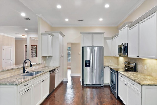 kitchen featuring white cabinetry, sink, ornamental molding, stainless steel appliances, and light stone countertops