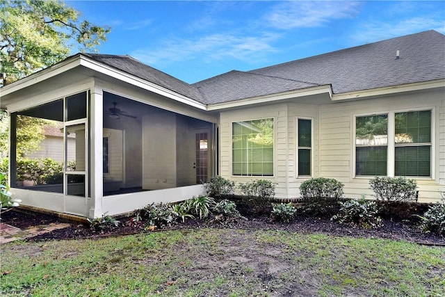 view of side of property with ceiling fan and a sunroom