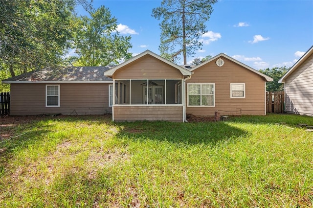 back of house with a sunroom and a lawn