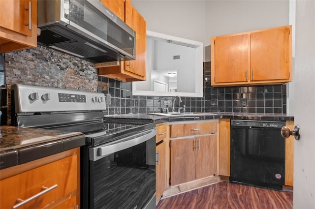 kitchen with dark wood-type flooring, sink, appliances with stainless steel finishes, and tasteful backsplash