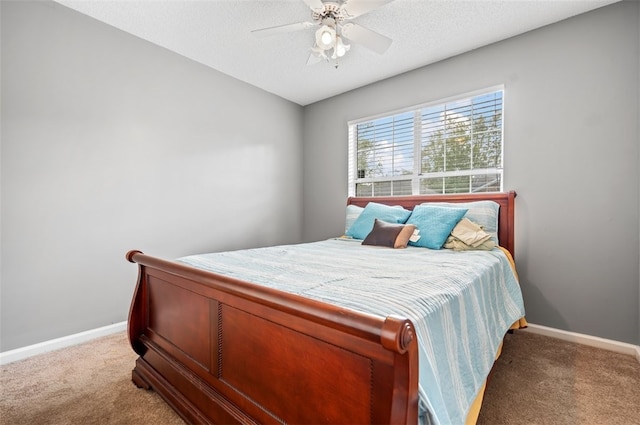 carpeted bedroom with ceiling fan and a textured ceiling