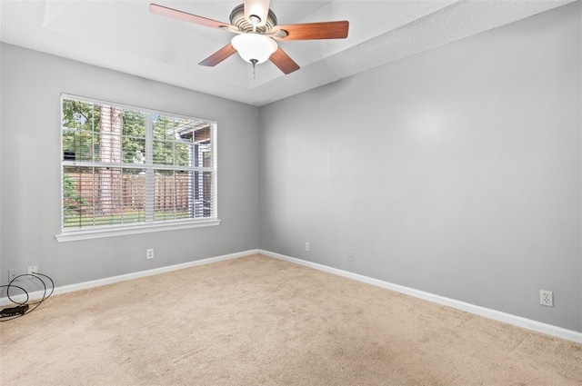 carpeted spare room featuring ceiling fan