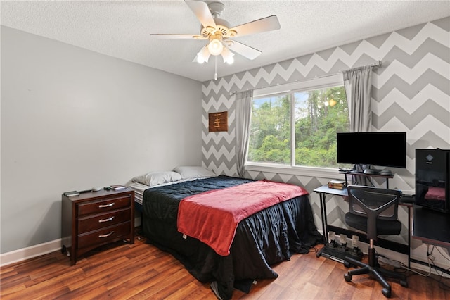 4936 US Highway 17 N, Brunswick, GA 31525 - bedroom with wallpapered walls, a textured ceiling, wood finished floors, a ceiling fan, and an accent wall