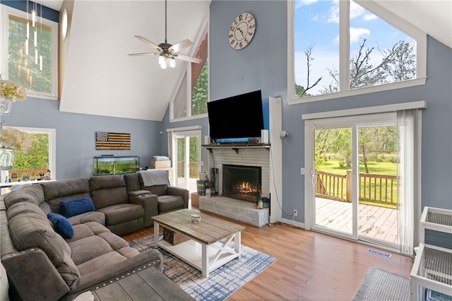 4936 US Highway 17 N, Brunswick, GA 31525 - living room with high vaulted ceiling, a brick fireplace, wood finished floors, a ceiling fan, and plenty of natural light