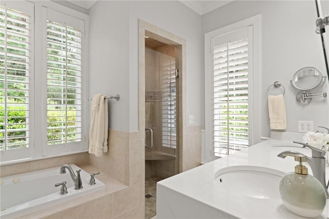 bathroom featuring a stall shower, a bath, plenty of natural light, and double vanity