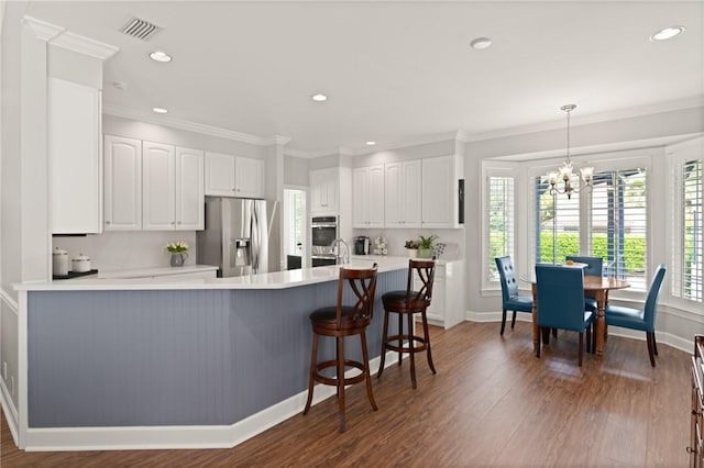 kitchen with stainless steel appliances, healthy amount of natural light, a chandelier, baseboards, and crown molding