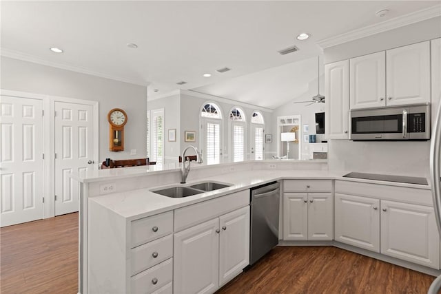kitchen featuring stainless steel appliances, a sink, dark wood-style flooring, light countertops, and ornamental molding