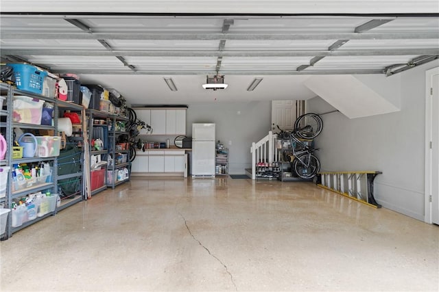 garage featuring freestanding refrigerator and a garage door opener