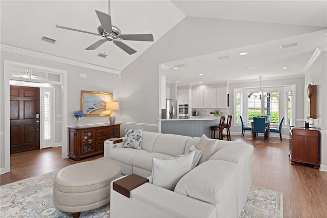 living area with vaulted ceiling, wood finished floors, a ceiling fan, crown molding, and recessed lighting