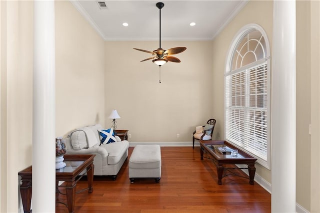 living area with dark hardwood / wood-style floors, ceiling fan, and crown molding