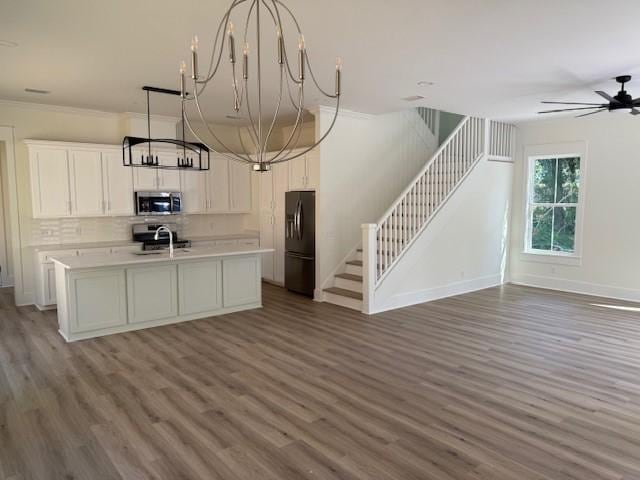 117 Quamley Wells Dr, Saint Simons Island, GA 31522 - kitchen with black fridge with ice dispenser, stainless steel microwave, open floor plan, a chandelier, and light countertops