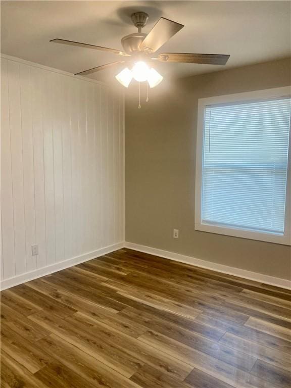 4726 New Jesup Hwy, Brunswick, GA 31520 - spare room featuring dark wood-style flooring, a ceiling fan, baseboards, and wooden walls
