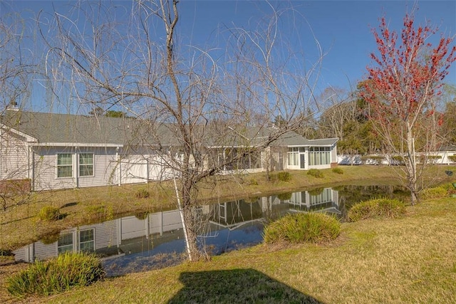 surrounding community featuring a lawn, fence, and a water view