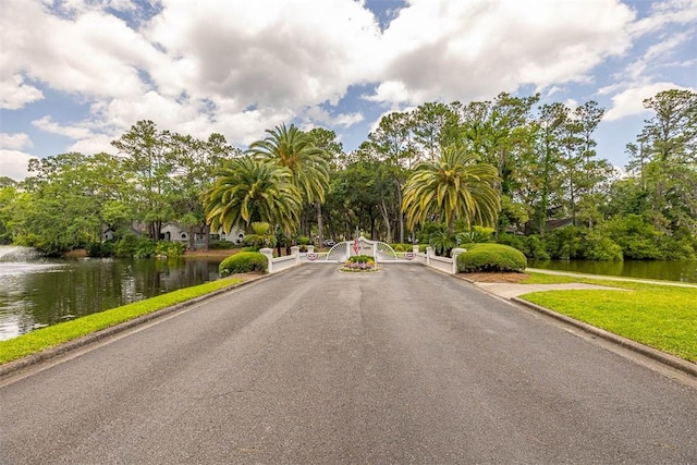 40 W Lake Dr, Saint Simons Island, GA 31522 - view of asphalt road with curbs, a water view, and a gated entry