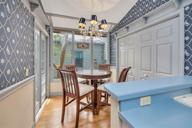 40 W Lake Dr, Saint Simons Island, GA 31522 - dining space featuring a chandelier, light wood-style floors, wallpapered walls, and baseboards