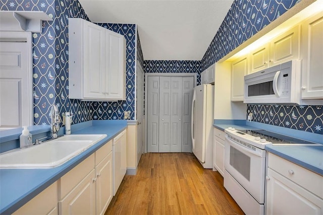 40 W Lake Dr, Saint Simons Island, GA 31522 - kitchen with white appliances, wallpapered walls, light wood-type flooring, a sink, and tasteful backsplash