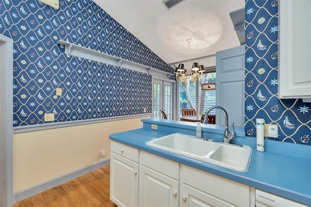 40 W Lake Dr, Saint Simons Island, GA 31522 - kitchen with a sink, wallpapered walls, a chandelier, light wood-style flooring, and vaulted ceiling